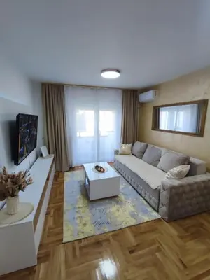 a living room with a couch and a table at Golden dream apartman in Pančevo