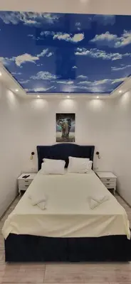 a bedroom with a large bed with a blue ceiling at Bumerang Apartmans, New Belgrade, Belgrade Arena in Belgrade