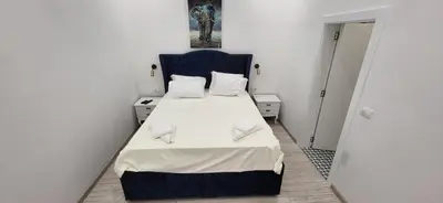 a small bedroom with a bed with a blue headboard at Bumerang Apartmans, New Belgrade, Belgrade Arena in Belgrade