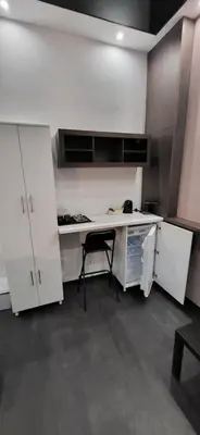 a kitchen with white cabinets and a black chair at Bumerang Apartmans, New Belgrade, Belgrade Arena in Belgrade