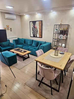 a living room with a blue couch and a table at Lux apartmann in Karaburma
