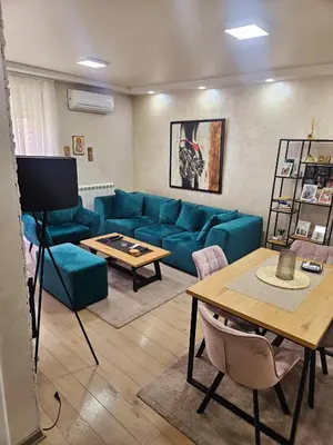 a living room with a blue couch and a table at Lux apartmann in Karaburma