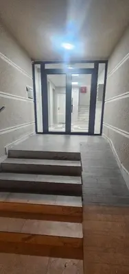 an empty hallway with blue doors and stairs at Lux apartmann in Karaburma