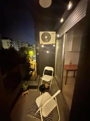 a balcony with two chairs and a clock on the wall at Angela apartment with 2 balconies in Belgrade