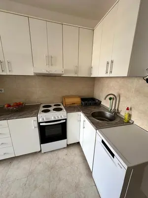 a kitchen with white cabinets and a stove and a sink at Angela apartment with 2 balconies in Belgrade