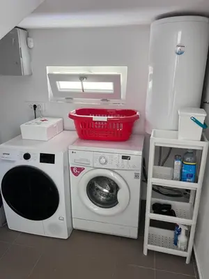 a laundry room with a washing machine and a basket on top at Villa Ana - Charming Appartments in Belgrade