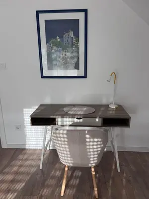 a desk with a lamp and a chair in a room at Villa Ana - Charming Appartments in Belgrade