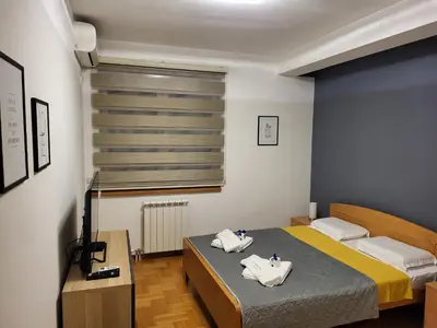 a small room with two beds and a television at BNB Apartments LUX in Belgrade