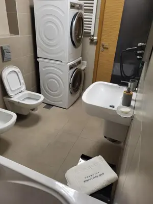 a bathroom with a toilet and a washing machine at BNB Apartments LUX in Belgrade