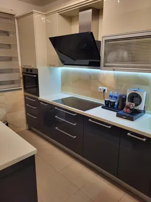 a kitchen with black cabinets and a flat screen tv at BNB Apartments LUX in Belgrade