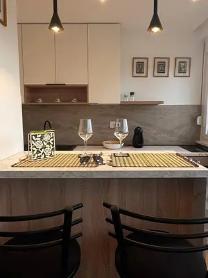 a kitchen with two wine glasses on a counter at Berenji Lux Apartment in Fontana