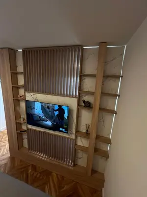 a room with a television and a wall with shelves at Berenji Lux Apartment in Fontana