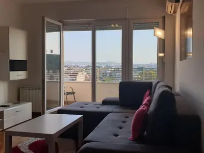 a living room with a couch and a table at Perla, family apartment with parking in Belgrade