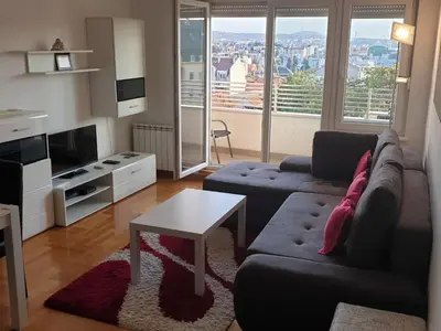a living room with a couch and a table at Perla, family apartment with parking in Belgrade