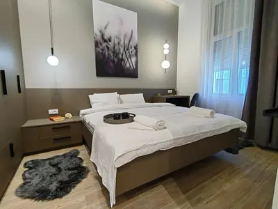 a bedroom with a large bed with white sheets at Rajiceva for 4 one bdr one living room Knez Mihailova in Belgrade