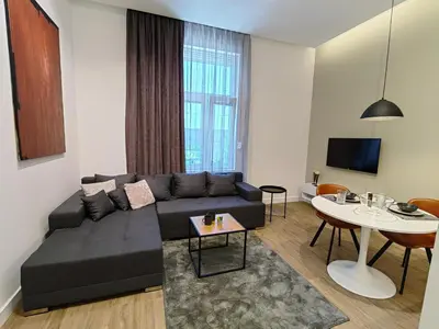 a living room with a black couch and a table at Rajiceva for 4 one bdr one living room Knez Mihailova in Belgrade