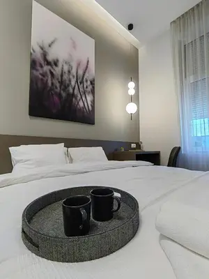 a bed with two black coffee mugs on it at Rajiceva for 4 one bdr one living room Knez Mihailova in Belgrade
