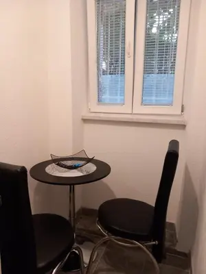 a small table and chairs in a room with a window at Studio Djurdjica in Belgrade