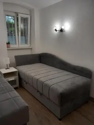 a couch sitting in a living room with a window at Studio Djurdjica in Belgrade
