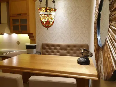a kitchen with a wooden table and aendant light at Shabby Chik, cozy apartment near St Sava Temple in Belgrade