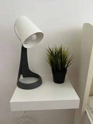 a lamp on a white shelf next to a plant at Apartman Kutak in Belgrade