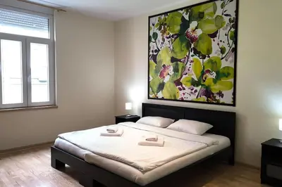 a bedroom with a bed with a painting on the wall at 150sqm 3BDR Family apartment in central Belgrade in Belgrade