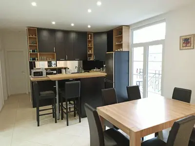 a kitchen with black cabinets and a table and chairs at 150sqm 3BDR Family apartment in central Belgrade in Belgrade