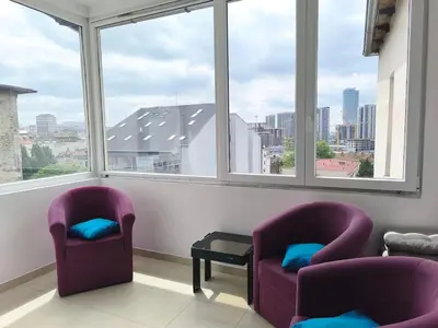two purple chairs sitting in a room with windows at Spacious 3BDR Central apartment near Terazije & BW in Belgrade