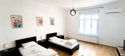 a living room with two beds and a window at Spacious 3BDR Central apartment near Terazije & BW in Belgrade