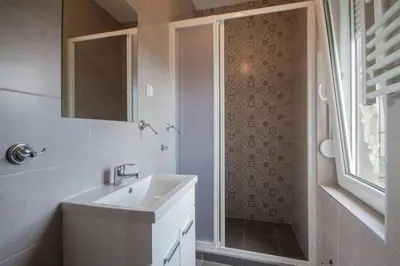 a bathroom with a sink and a shower with a mirror at Spacious 3BDR Central apartment near Terazije & BW in Belgrade