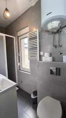 a bathroom with a toilet and a sink and a window at Spacious 3BDR Central apartment near Terazije & BW in Belgrade