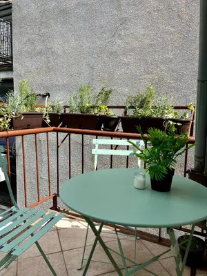 a table and chairs on a balcony with potted plants at Urban Oasis in Belgrade