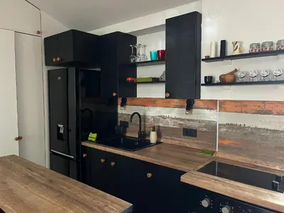 a kitchen with black cabinets and a sink at Urban Oasis in Belgrade