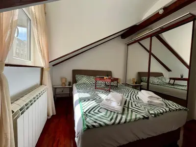 a bedroom with a bed and a window at Urban Oasis in Belgrade