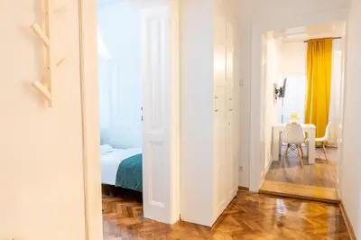 a bedroom with a bed and a table with a chair at Central and Comfy 2BDR apartment near Parliament in Belgrade
