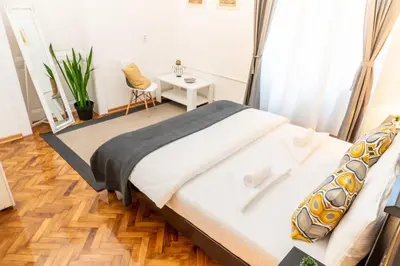 a bedroom with a bed with a table and a chair at Central and Comfy 2BDR apartment near Parliament in Belgrade