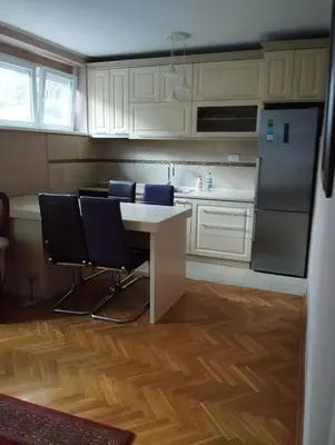 a kitchen with white cabinets and a table and chairs at Luna in Vračar (historical)