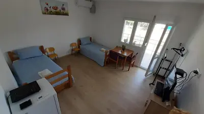 a small room with a bed and a table and chairs at Udobna Dvokrevetna Soba Sa Terasom #2 in Mladenovac