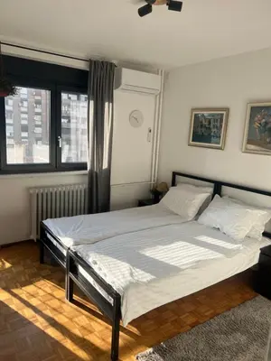a bedroom with a large bed with white sheets at Oasis Residences B in Belgrade