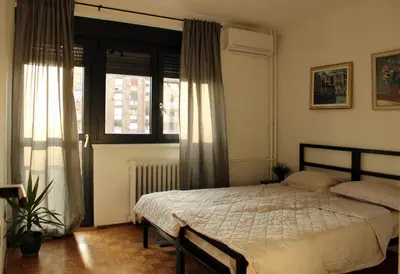 a bedroom with a bed and a window at Oasis Residences B in Belgrade