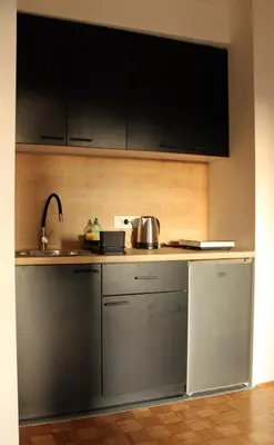 a kitchen with stainless steel appliances and black cabinets at Oasis Residences B in Belgrade