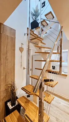 a wooden spiral staircase in a living room with wooden floors at Dorcol deluxe apartment in Belgrade