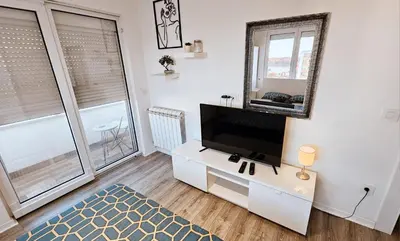 a living room with a flat screen tv on a white cabinet at Dorcol deluxe apartment in Belgrade