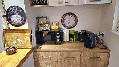 a counter with a microwave and a clock on a wall at Dorcol deluxe apartment in Belgrade