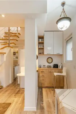 a kitchen with white cabinets and a dining table at Dorcol deluxe apartment in Belgrade