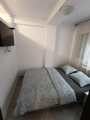 a bedroom with a bed and a flat screen tv at Vist 2 apartment in Tošin Bunar