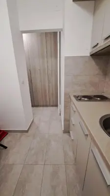 a kitchen with white cabinets and a counter top at Vist 2 apartment in Tošin Bunar