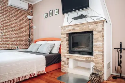 a bedroom with a bed and a fireplace with a tv at King Residences City Center in Belgrade