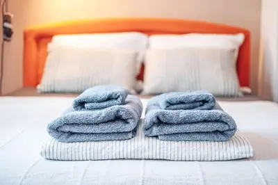 a pile of towels sitting on top of a bed at King Residences City Center in Belgrade