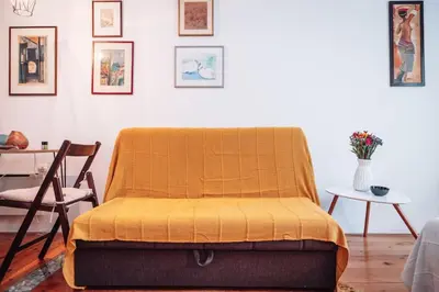 a bed with a yellow blanket on it in a room at King Residences City Center in Belgrade